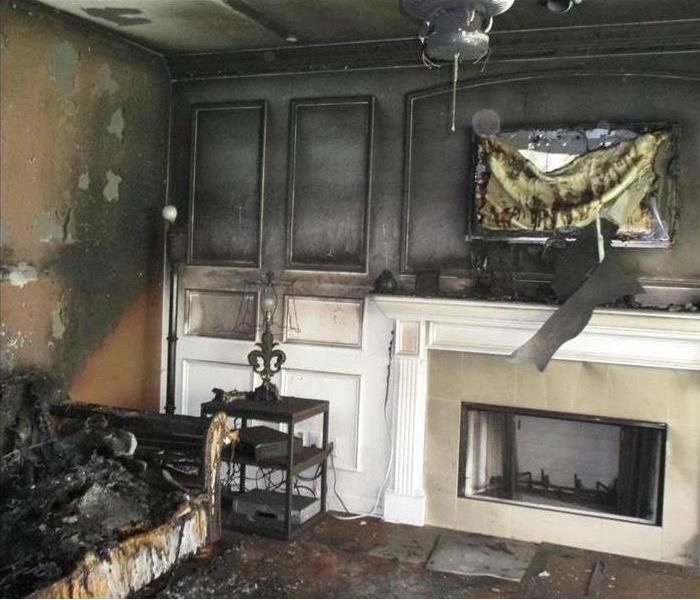 Heavy fire and smoke damage visible in a living room