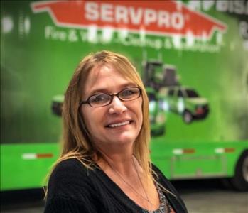 Female in front of a SERVPRO trailer