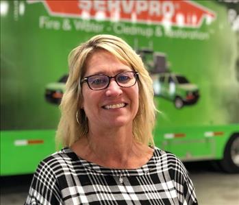 Female in front of a SERVPRO trailer