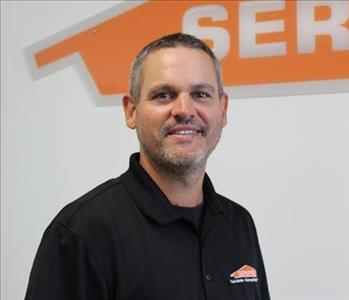 Servpro Employee in from of a SERVPRO signage