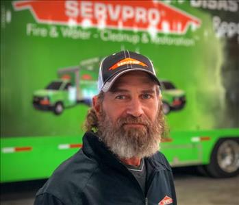 older man in front of a SERVPRO trailer