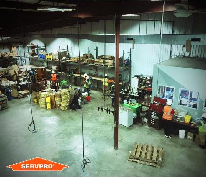several SERVPRO employees cleaning a warehouse and its  contents from a fire.
